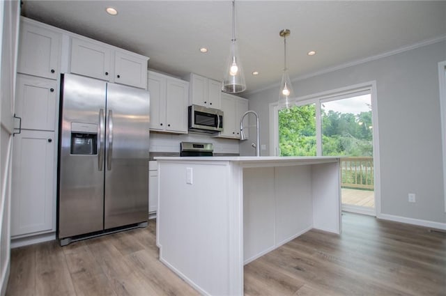74 Preacher Smith Rd, Silver Creek, GA 30173 - kitchen with appliances with stainless steel finishes, crown molding, light wood-type flooring, white cabinetry, and a center island with sink