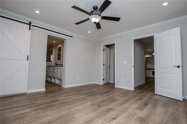 74 Preacher Smith Rd, Silver Creek, GA 30173 - unfurnished bedroom with wood finished floors, ornamental molding, baseboards, a barn door, and recessed lighting