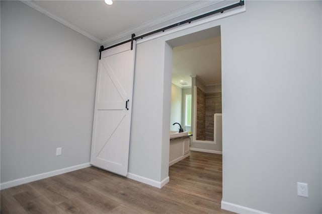 74 Preacher Smith Rd, Silver Creek, GA 30173 - unfurnished bedroom with crown molding, wood finished floors, baseboards, a barn door, and recessed lighting