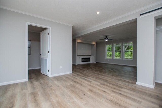 74 Preacher Smith Rd, Silver Creek, GA 30173 - unfurnished living room with ornamental molding, ceiling fan, baseboards, a fireplace, and a barn door