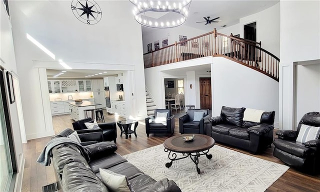 2900 Orchard Rd SW, Conyers, GA 30094 - living room featuring stairs, a towering ceiling, wood finished floors, and a chandelier