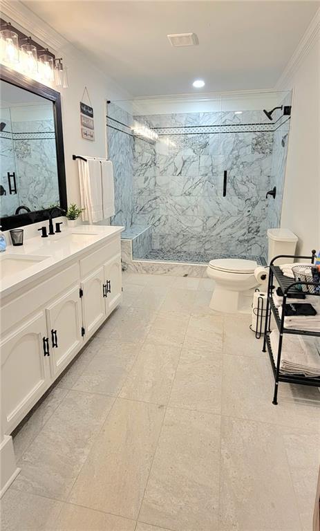 2900 Orchard Rd SW, Conyers, GA 30094 - full bathroom with a marble finish shower, vanity, crown molding, and toilet