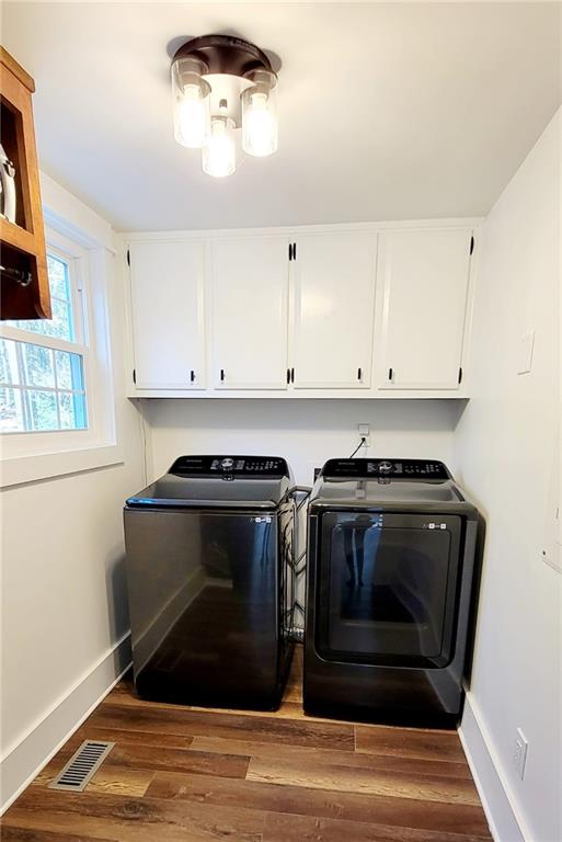 2900 Orchard Rd SW, Conyers, GA 30094 - laundry room with cabinet space, washer and dryer, wood finished floors, and baseboards