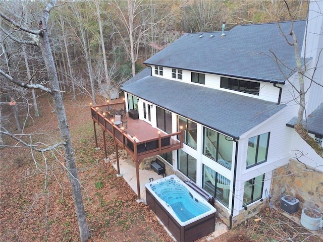 2900 Orchard Rd SW, Conyers, GA 30094 - back of property featuring a shingled roof, a hot tub, a wooden deck, and a patio area