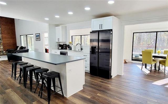 2900 Orchard Rd SW, Conyers, GA 30094 - kitchen featuring black fridge with ice dispenser, a sink, a kitchen breakfast bar, a center island, and dark wood-style flooring