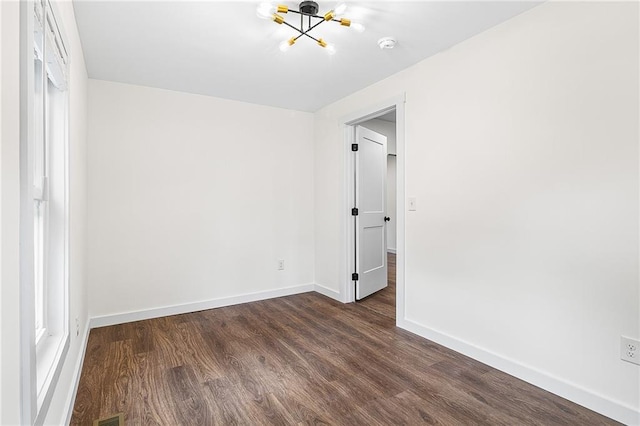 578 Cedar Ave, Atlanta, GA 30318 - empty room with a chandelier, dark wood-style flooring, and baseboards