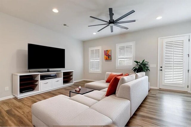 living room featuring light hardwood / wood-style flooring and ceiling fan