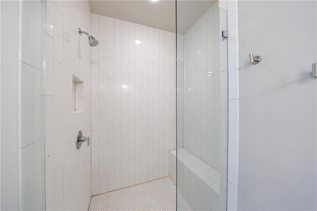 bathroom featuring tiled shower and tile patterned floors