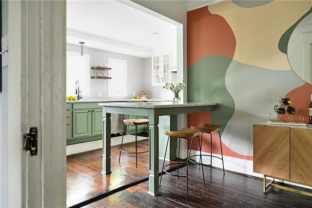 bar featuring green cabinetry, white cabinetry, hanging light fixtures, and dark hardwood / wood-style floors