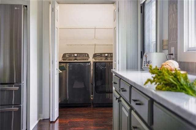 clothes washing area featuring dark wood-type flooring and washer and dryer