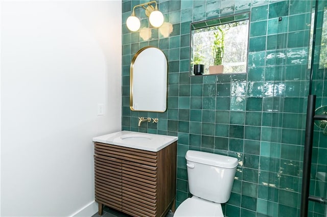 bathroom featuring toilet, vanity, tile walls, and walk in shower