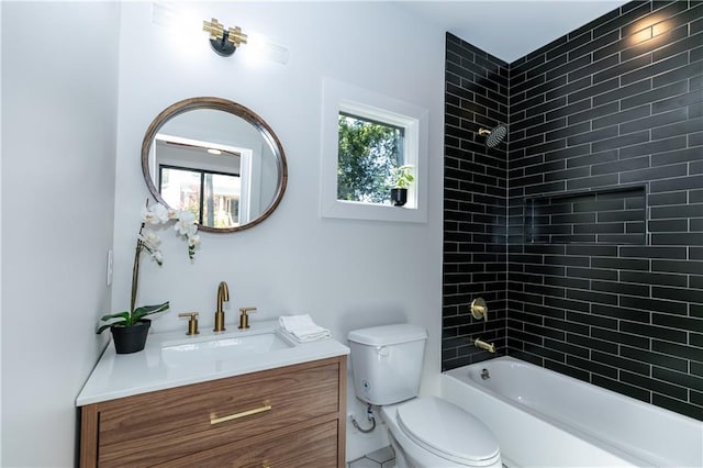 full bathroom with vanity, tiled shower / bath combo, and toilet