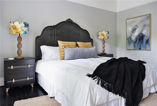 bedroom with ornamental molding and dark hardwood / wood-style floors