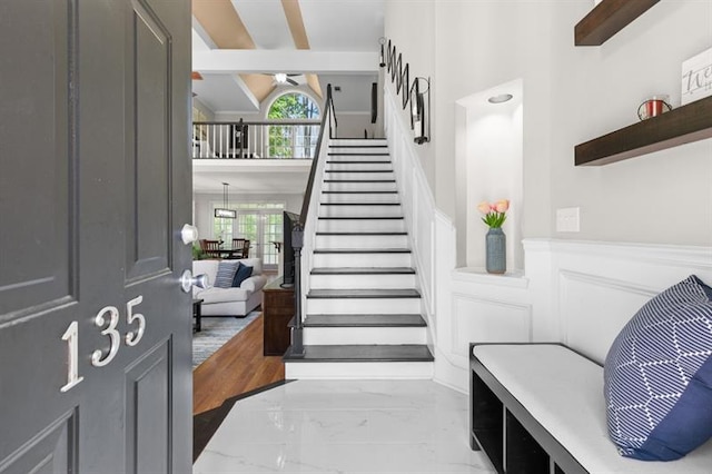 stairs featuring vaulted ceiling with beams