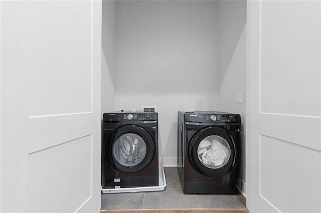 laundry area with light tile patterned floors and washing machine and dryer