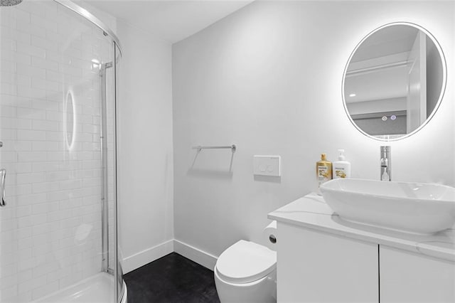 bathroom featuring a shower with door, toilet, and vanity