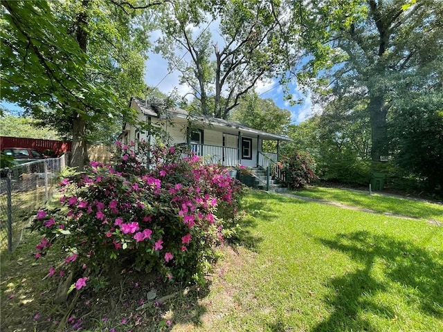 view of yard featuring covered porch and fence