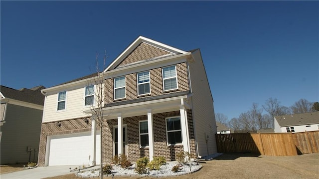 view of front of property with a garage, driveway, brick siding, and fence