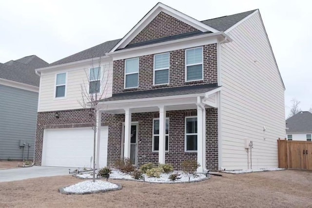 traditional-style home featuring a garage, concrete driveway, brick siding, and fence