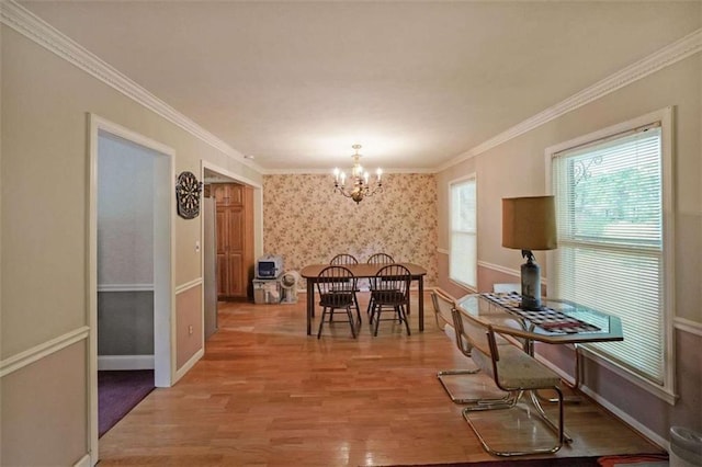 6880 Mark Turner Rd, Lithia Springs, GA 30122 - dining area with light wood finished floors, a chandelier, crown molding, and wallpapered walls