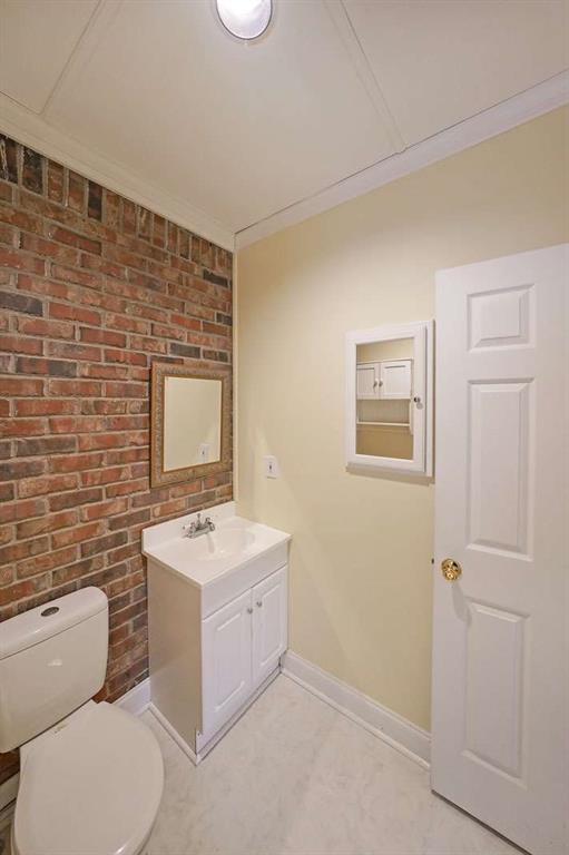 6880 Mark Turner Rd, Lithia Springs, GA 30122 - bathroom with vanity and brick wall