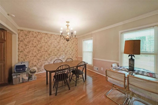 6880 Mark Turner Rd, Lithia Springs, GA 30122 - dining space with a chandelier, light wood-style floors, and crown molding