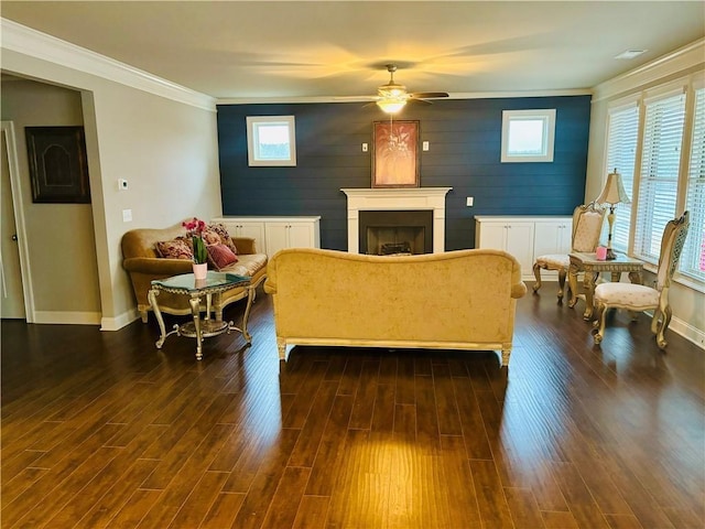 living room featuring ornamental molding, dark hardwood / wood-style floors, wooden walls, and ceiling fan