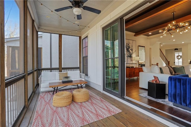 sunroom with ceiling fan with notable chandelier