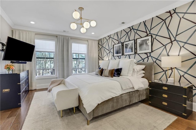 bedroom featuring dark wood-type flooring, crown molding, and a chandelier