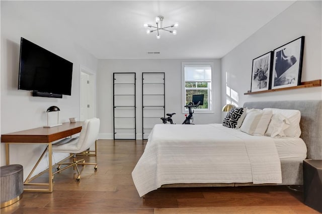 bedroom featuring dark hardwood / wood-style flooring and a notable chandelier