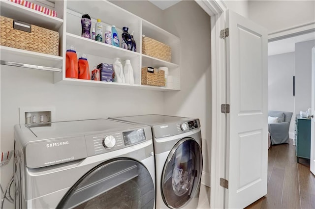 laundry room with washer and clothes dryer and dark hardwood / wood-style flooring