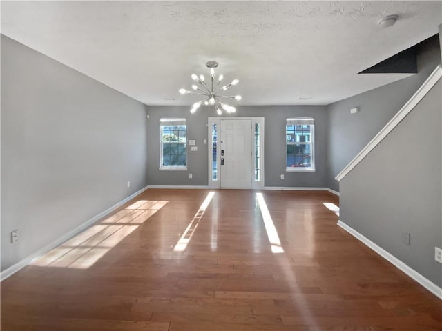 entrance foyer featuring hardwood / wood-style flooring and an inviting chandelier