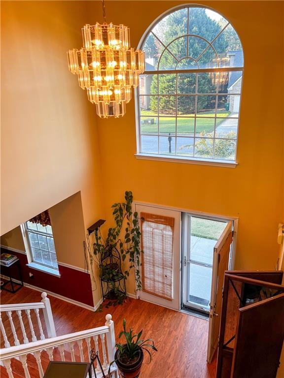 entrance foyer featuring hardwood / wood-style flooring, a healthy amount of sunlight, and an inviting chandelier