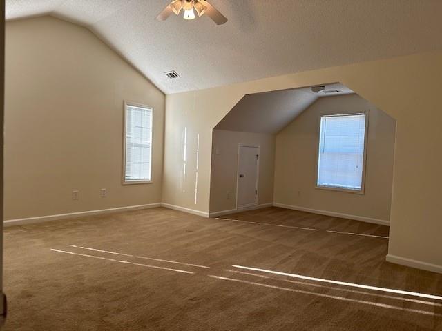 635 Beddick Ln, Atlanta, GA 30349 - additional living space featuring vaulted ceiling, carpet floors, healthy amount of natural light, a ceiling fan, and baseboards