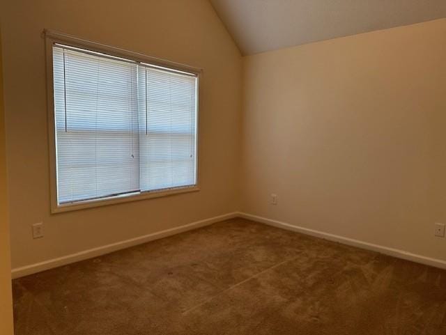 635 Beddick Ln, Atlanta, GA 30349 - unfurnished room with dark colored carpet, baseboards, and vaulted ceiling