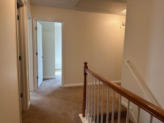635 Beddick Ln, Atlanta, GA 30349 - hall with attic access, an upstairs landing, carpet, and baseboards