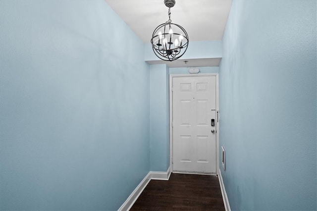 doorway to outside with a notable chandelier and dark hardwood / wood-style floors