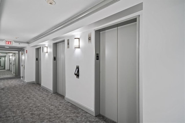 corridor with elevator and dark carpet