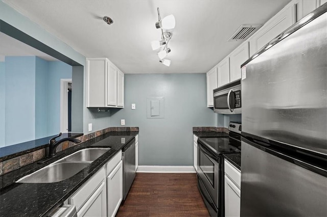 kitchen featuring stainless steel appliances, white cabinetry, sink, and dark stone counters