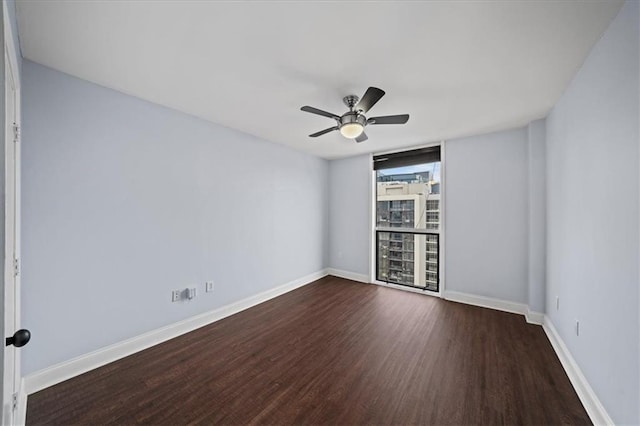 empty room featuring ceiling fan, floor to ceiling windows, and dark hardwood / wood-style flooring