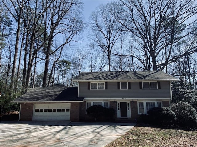 view of front of house with an attached garage, brick siding, and driveway