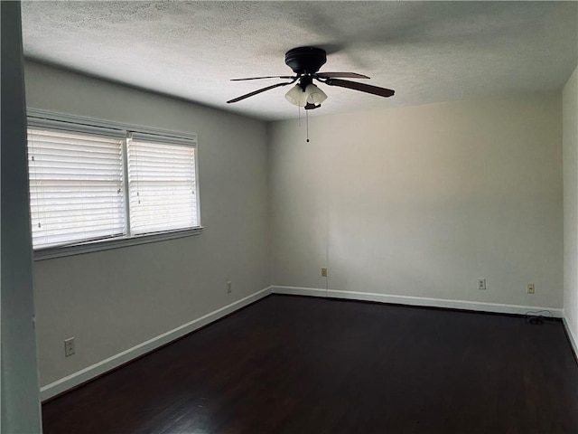 empty room featuring ceiling fan, a textured ceiling, baseboards, and dark wood-style flooring