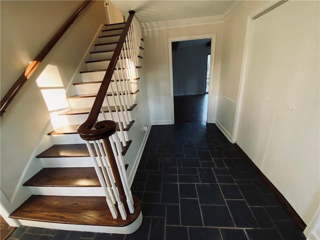 stairway featuring a wainscoted wall and crown molding