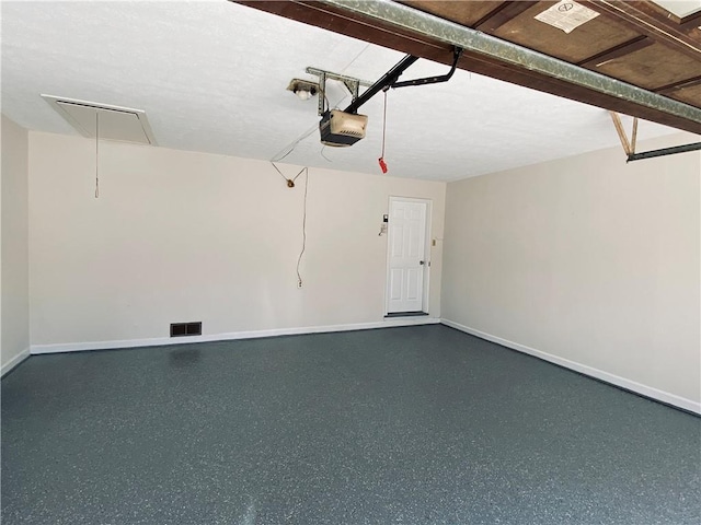 garage featuring visible vents, a garage door opener, and baseboards