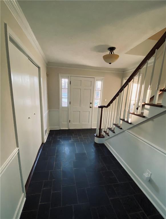 entrance foyer with stairs and ornamental molding