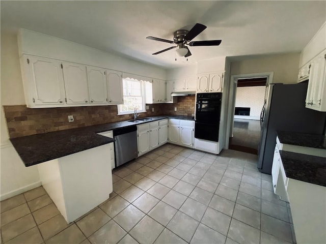 kitchen with dark countertops, dishwasher, a peninsula, and a sink