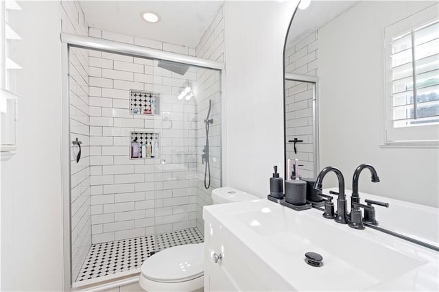 bathroom featuring vanity, a shower with shower door, and toilet