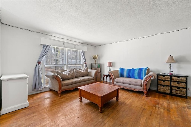 living room with wood-type flooring and a textured ceiling