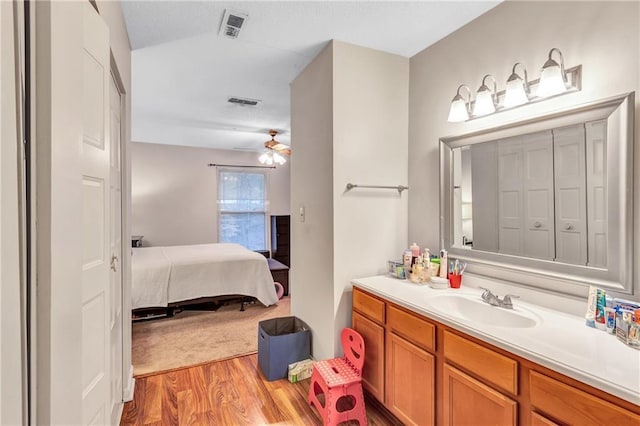 ensuite bathroom featuring visible vents, ensuite bath, ceiling fan, wood finished floors, and vanity