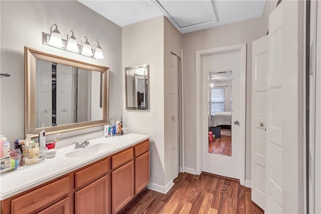 bathroom featuring wood finished floors, vanity, and baseboards